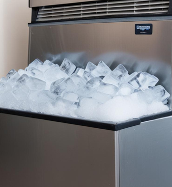 A technician performing repairs on a commercial ice machine, focusing on restoring full functionality and efficiency for business operations. Expert Commercial Ice Machine Repairs