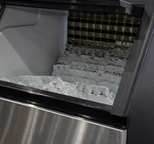Skilled ice machine technician repairing an ice maker in a commercial kitchen, ensuring optimal performance and reliability. Professional Ice Machine Technician
